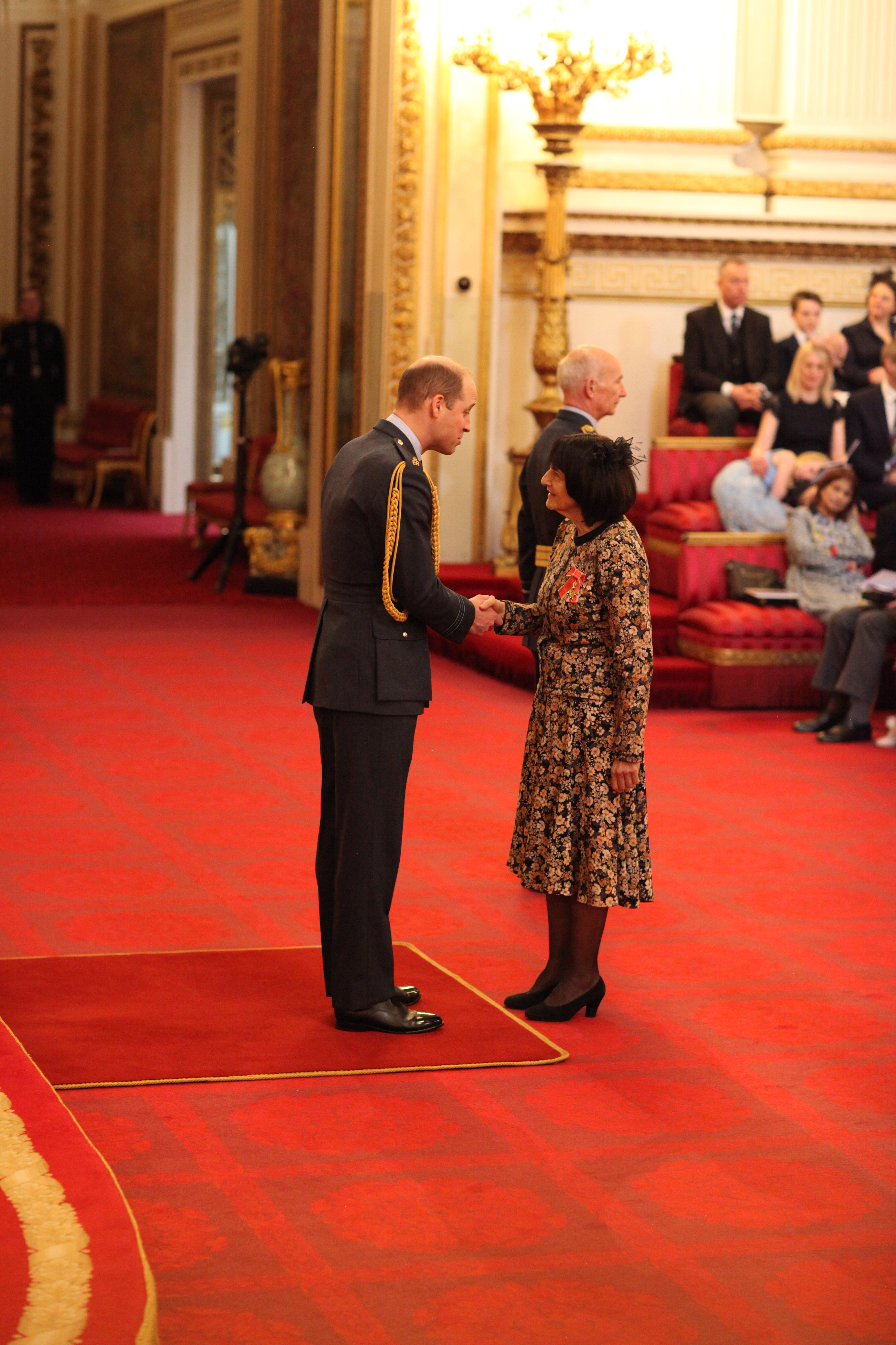 Judy Sebba receiving an OBE from the Duke of Cambridge
