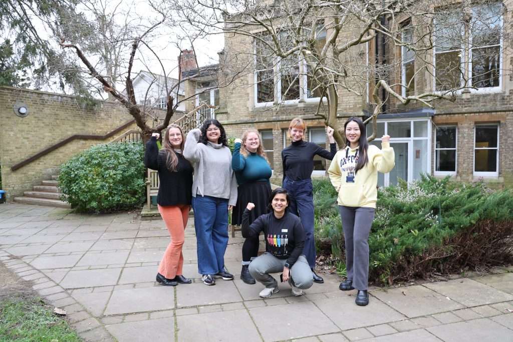 A group of students holding their arms up